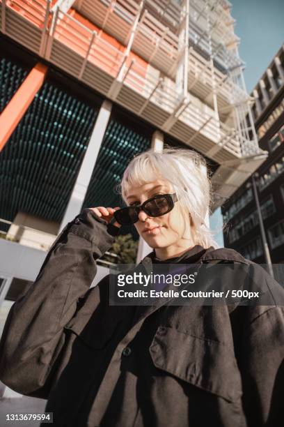 low angle view of woman wearing sunglasses while standing against building,marseille,france - 馬賽族 個照片及圖片檔