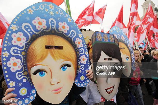 Wearing masks activists of the pro-Kremlin youth movement "Nashi" carry their flags as they rally in front of the VVts All Russian Exhibition Centre,...