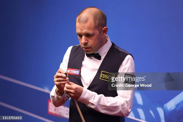 Barry Hawkins of England chalks the cue during the Betfred World Snooker Championship Round One match between Matthew Selt of England and Barry...
