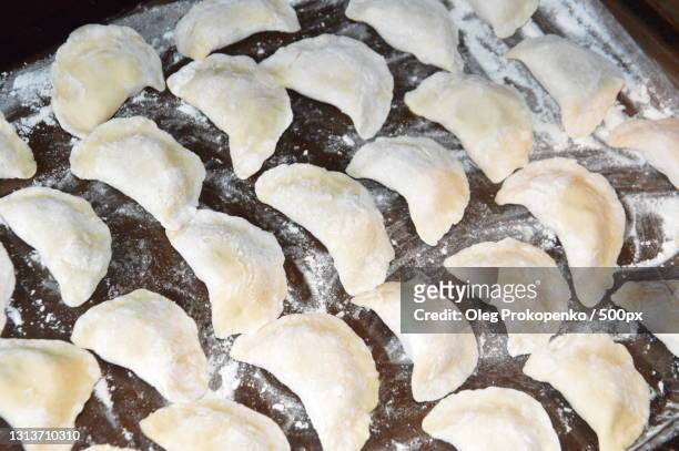 high angle view of dumplings in cooking pan - oleg prokopenko stock pictures, royalty-free photos & images