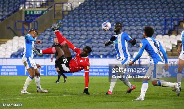 Daryl Dike of Barnsley scores the opening goal with an overhead kick during the Sky Bet Championship match between Huddersfield Town and Barnsley at...