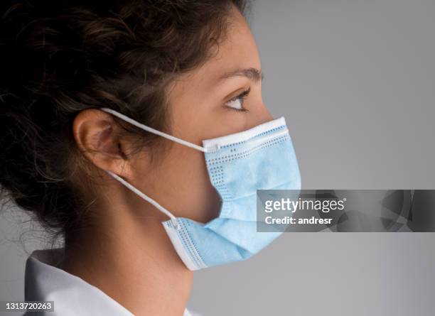 female doctor wearing a facemask - protective face mask side stock pictures, royalty-free photos & images