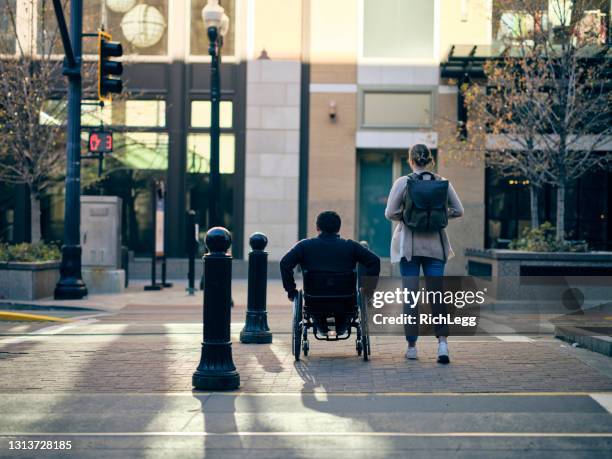 homme handicapé et un ami dans un centre-ville - paraplegic woman photos et images de collection