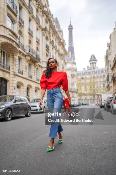 Emilie Joseph @in_fashionwetrust wears a red vintage linen power shoulder top worn backwards with plunging neckline in the back, blue denim high rise...