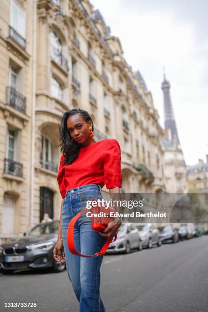 Emilie Joseph @in_fashionwetrust wears a red vintage linen power shoulder top worn backwards with plunging neckline in the back, blue denim high rise...