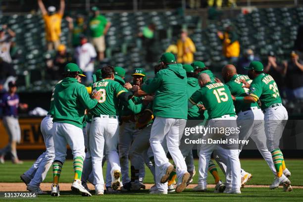 Ramon Laureano of the Oakland Athletics celebrates with his teammates after reaching first on an error to walk off in the tenth inning against the...