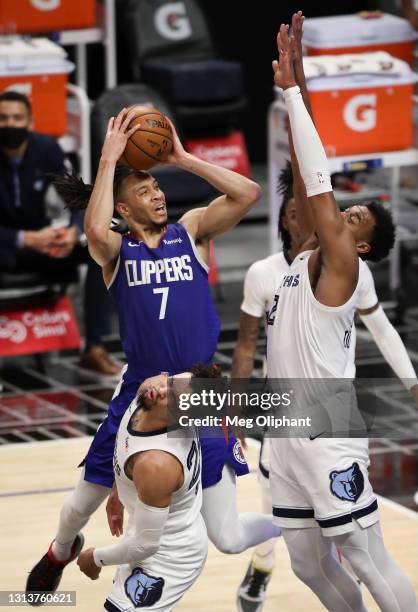 Amir Coffey of the LA Clippers attempts to shoot defended by Xavier Tillman and fouled by Dillon Brooks of the Memphis Grizzlies at Staples Center on...