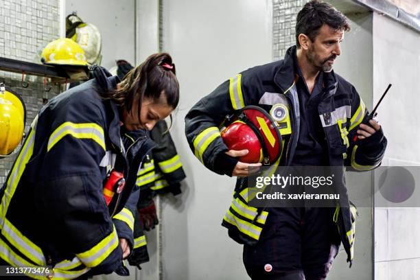 firefighters dressing and communicating at fire station - walkie talkie imagens e fotografias de stock