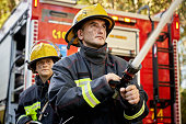 Action Portrait of Male and Female Firefighting Hose Team
