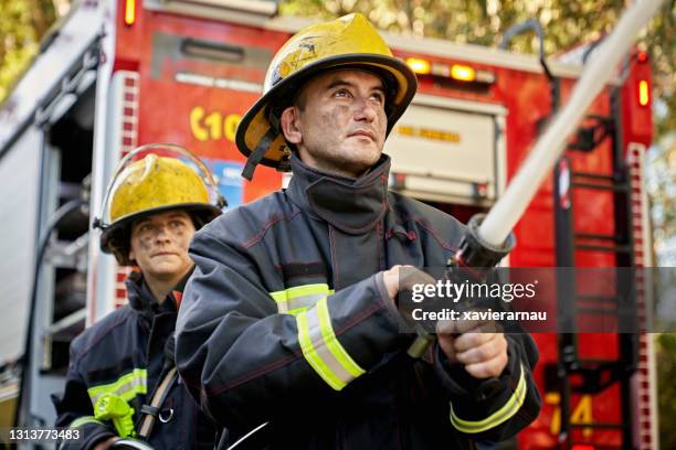 男女消防軟管團隊的行動肖像 - firefighter 個照片及圖片檔