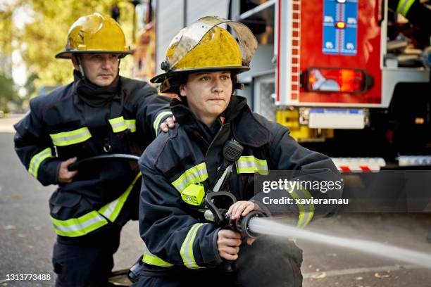 High Resolution Firefighting Candid Portrait Of Mid Adult Firefighting Hose Team High-Res Stock ...