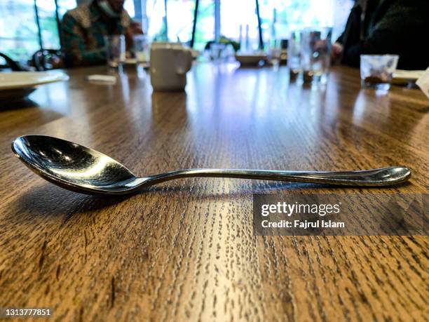 close up shot of spoon on wooden table - crack spoon stock pictures, royalty-free photos & images