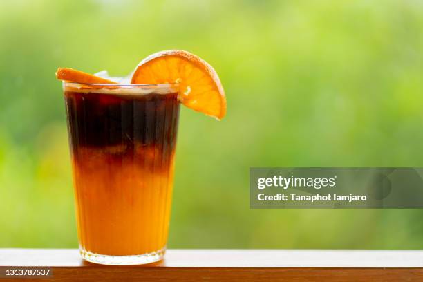 americano coffee mixed with orange juice with orange slices on the glass. - americano photos et images de collection