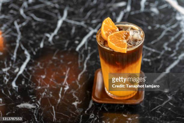 americano coffee mixed with orange juice with orange slices on the glass. - orange juice stock-fotos und bilder