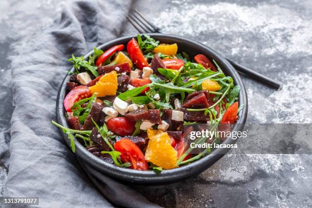 salad with aragula, tomatoes, orange, beetroot and feta - roquette photos et images de collection