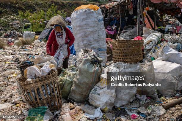 Scavenger looks for plastic bottles at Jabon landfill on April 22, 2021 in Sidoarjo, East Java, Indonesia. The Indonesian Government has through the...