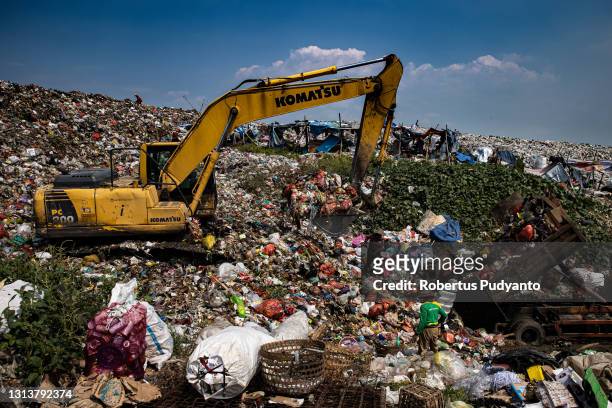 An excavator scrapes the waste at Jabon landfill on April 22, 2021 in Sidoarjo, East Java, Indonesia. The Indonesian Government has through the...