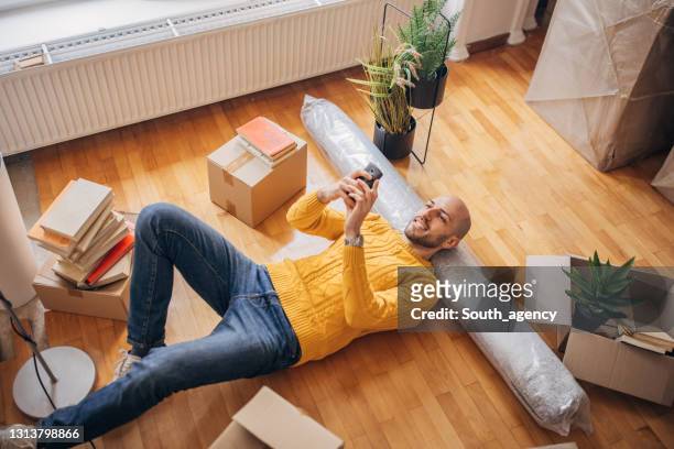 man lying on the floor in new home - man on the move stock pictures, royalty-free photos & images