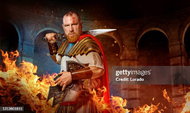 a redhead warrior gladiator in a fire filled fighting arena - gladiator armour stock pictures, royalty-free photos & images