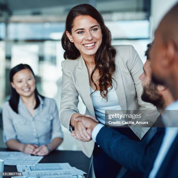 shot of a young businesswoman shaking hands with a colleague during a meeting in a modern office - new hire stock pictures, royalty-free photos & images