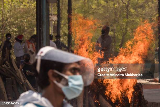 Multiple funeral pyres can be seen burning as people perform the last rites of their relatives who died of the Covid-19 coronavirus disease at a...