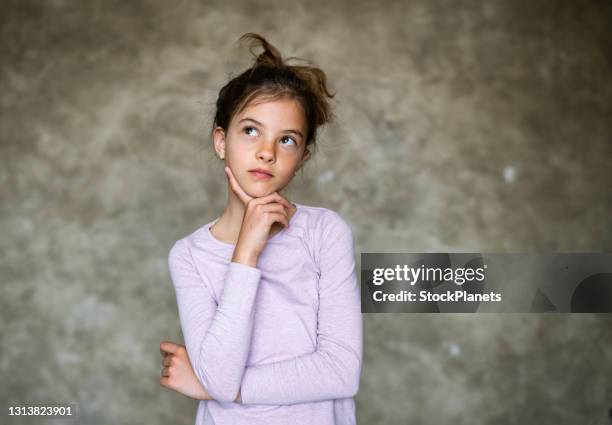 retrato de menina bonita segurando a mão no queixo e pensando - suspicion - fotografias e filmes do acervo