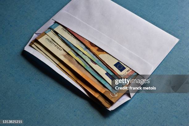 euro banknotes in an envelope - envelop stockfoto's en -beelden