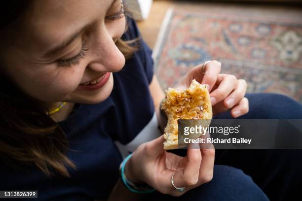 teenage girl eating a crumpet - crumpet fotografías e imágenes de stock