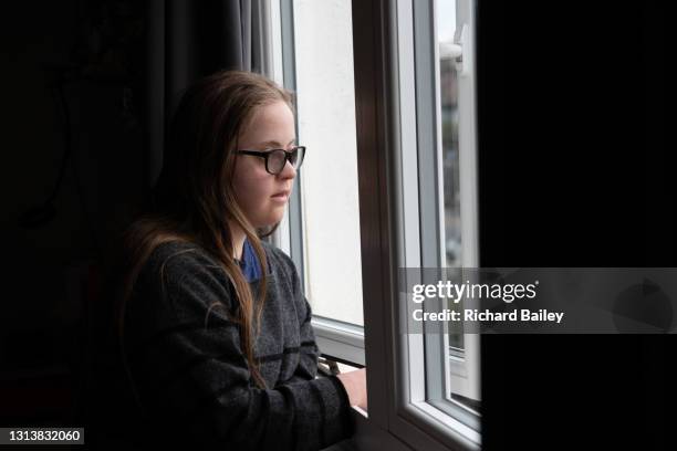 teenage girl looking out of her bedroom window - bullying prevention stock pictures, royalty-free photos & images