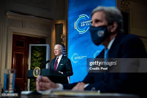 President Joe Biden delivers remarks as Special Presidential Envoy for Climate and former Secretary of State John Kerry listens during a virtual...