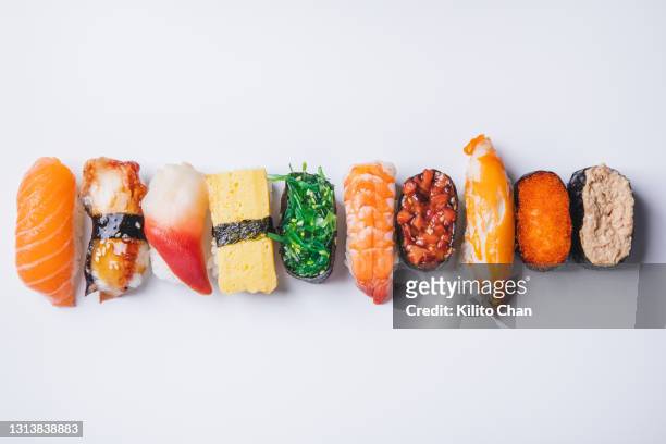 overhead view of variety of sushi on against a white background - japanese food stock pictures, royalty-free photos & images