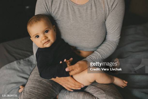 new born baby sleeping, smiling on mother`s arm. - eltern baby stockfoto's en -beelden