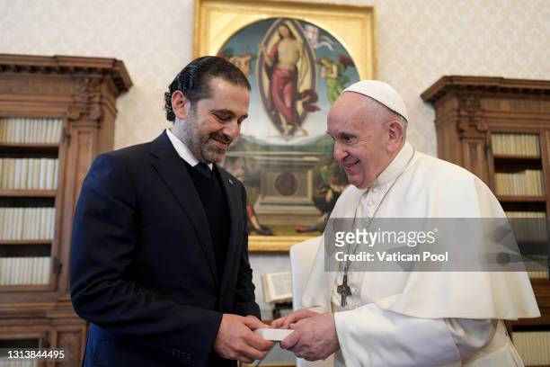 In this photograph provided by Vatican Media, Pope Francis exchanges gifts with Lebanon’s Prime Minister-designate Saad Hariri during a private...