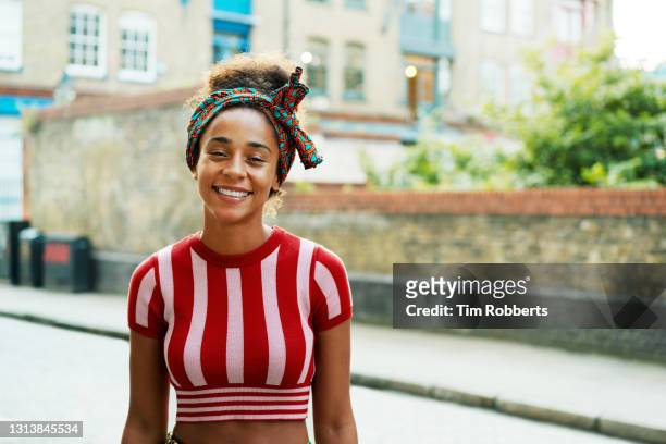 smiling woman looking at camera - junge frau allein stock-fotos und bilder