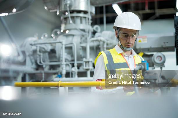 industrial engineer inspecting heating water supply temperature system in boiler room by visual check. boiler water supply system for production line process. - valvola di sfiato foto e immagini stock