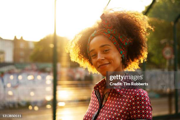 woman looking at camera at sunset - posa alternativa - fotografias e filmes do acervo