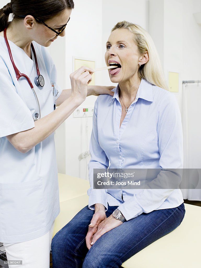 Female doctor examing womans mouth