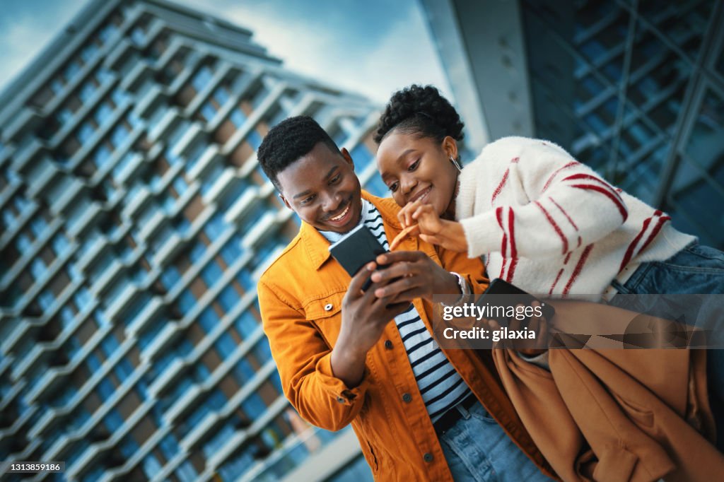 Young Afro American couple enjoying sunny day and taking selfies.