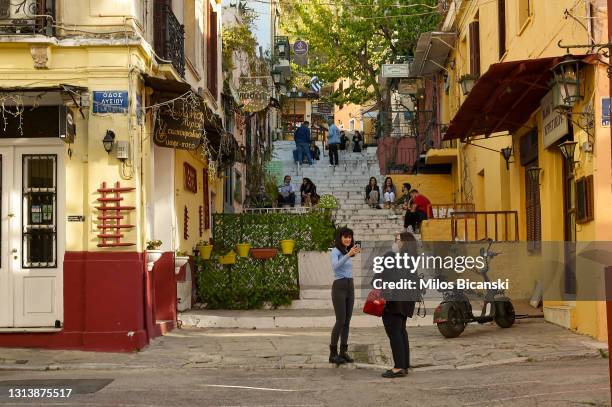 People wearing protective face masks walk in Plaka on April 20, 2021 in Athens, Greece. Greece's full reopening is scheduled for May 14, but tourists...