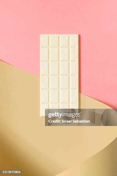 top view of a whole bar of white chocolate on pink and brown background. - chocolate top view stock-fotos und bilder