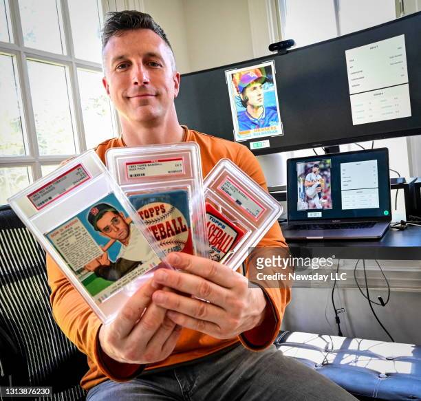 Kevin Lenane, founder of an artificial intelligence company called Genamint holds baseball cards in his home in Stony Brook, New York on April 20,...