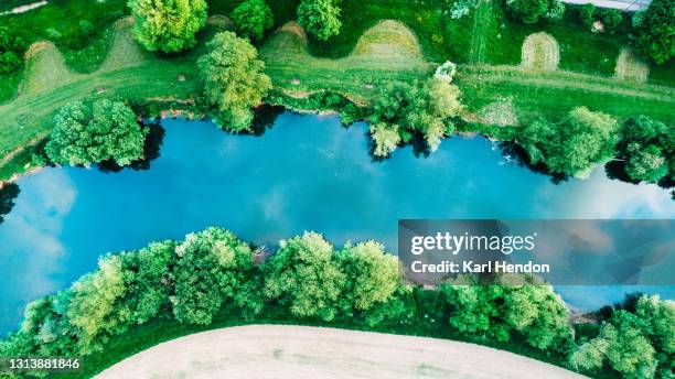 an aerial daytime view looking down at a river surrounded by trees - stock photo - england river landscape stock pictures, royalty-free photos & images