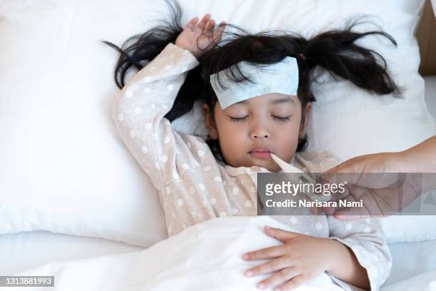 mother is using digital medical electronic thermometer measures temperature of the kid or patient. medical illness and fever concept. - headache child fotografías e imágenes de stock