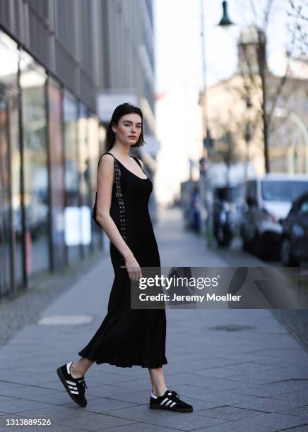 Celine Bethmann wearing black midi dress, black bag and black Adidas sneakers on April 20, 2021 in Berlin, Germany.