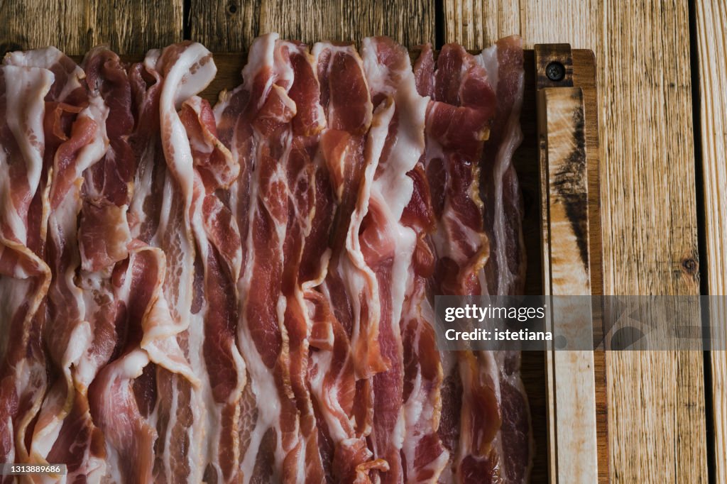 Dry cured pork belly, pork meat strips on rustic wood table