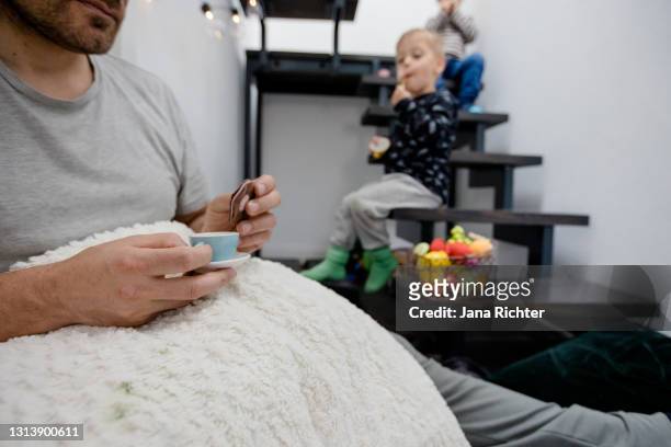 father is sitting in the hallway with his twins having a picnic - role reversal stock pictures, royalty-free photos & images