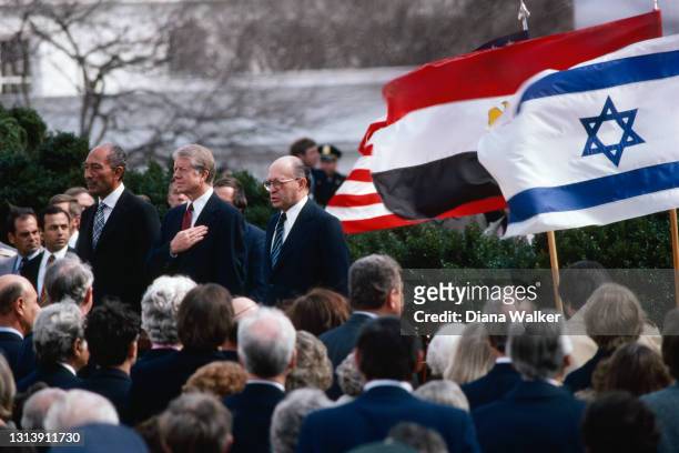 View of, standing center, from left. Egyptian President Anwar El-Sadat, US President Jimmy Carter, and Israeli Prime Minister Menachem Begin as they...