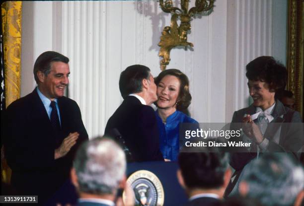 President Jimmy Carter kisses First Lady Rosalynn Carter before an audience of administration officials and White House staffers in the East Room of...