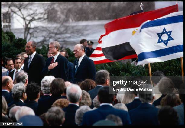 View of, standing center, from left. Egyptian President Anwar El-Sadat, US President Jimmy Carter, and Israeli Prime Minister Menachem Begin as they...