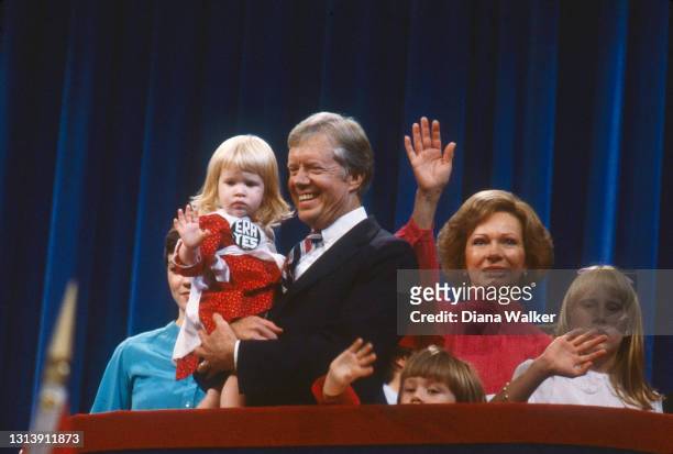 View of US President Jimmy Carter, holding his grand-daughter Sarah Carter, First Lady Rosalynn Carter , and their daughter, Amy Carter , along with...